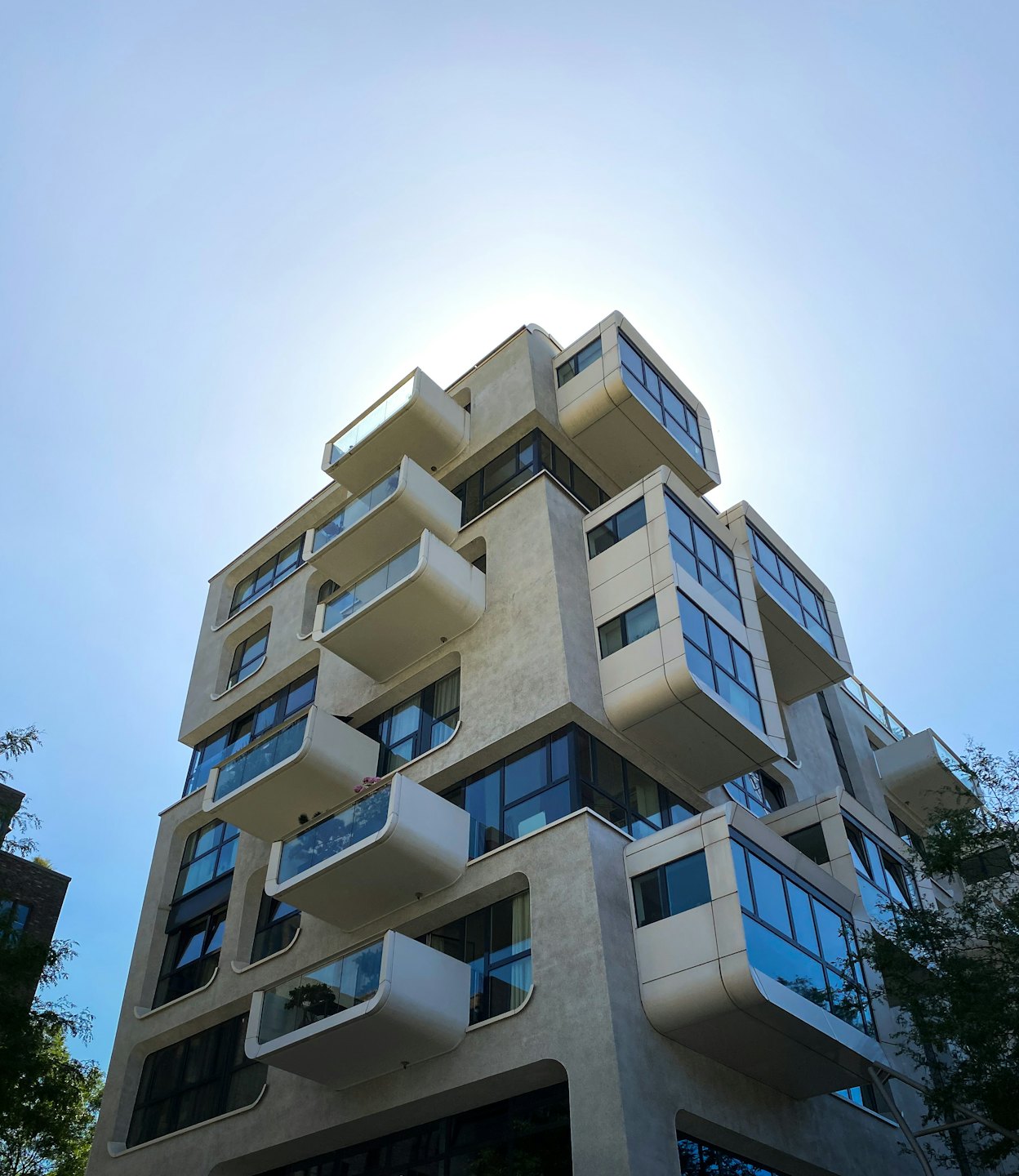 Modern residential building with rounded balconies and concrete facade.