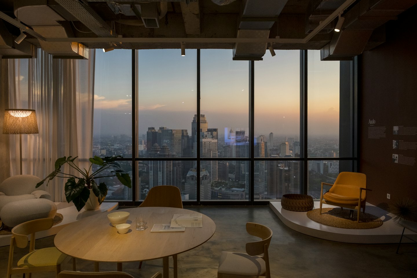 Modern office interior with furniture overlooking a city skyline.