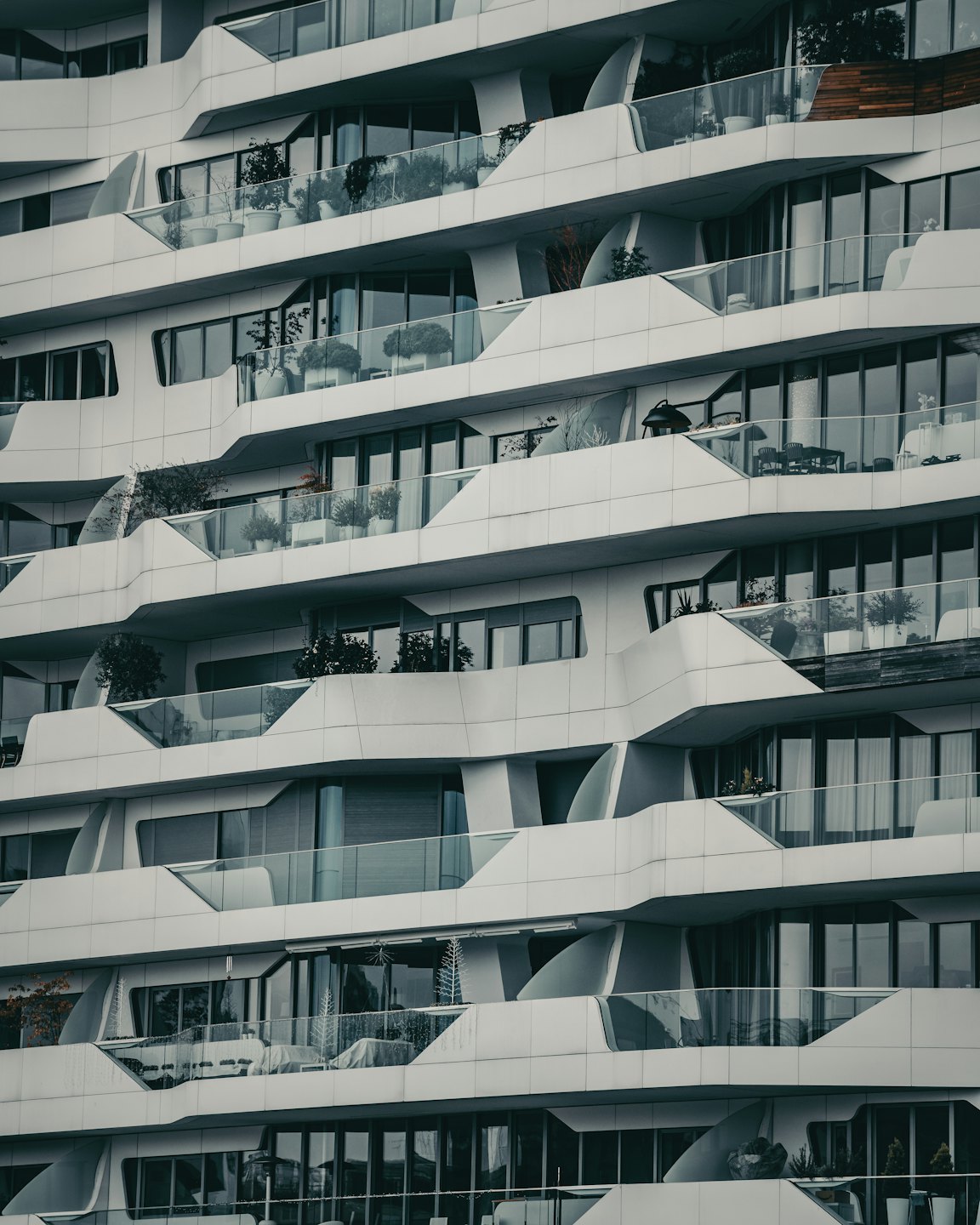 Modern apartment building with white curvilinear architecture and glass balconies.